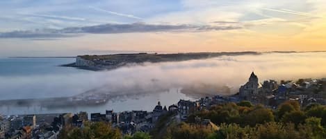 Une ville côtière qui se distingue par son église imposante, son port souvent enveloppé de brume et un panneau indiquant « Poole ».