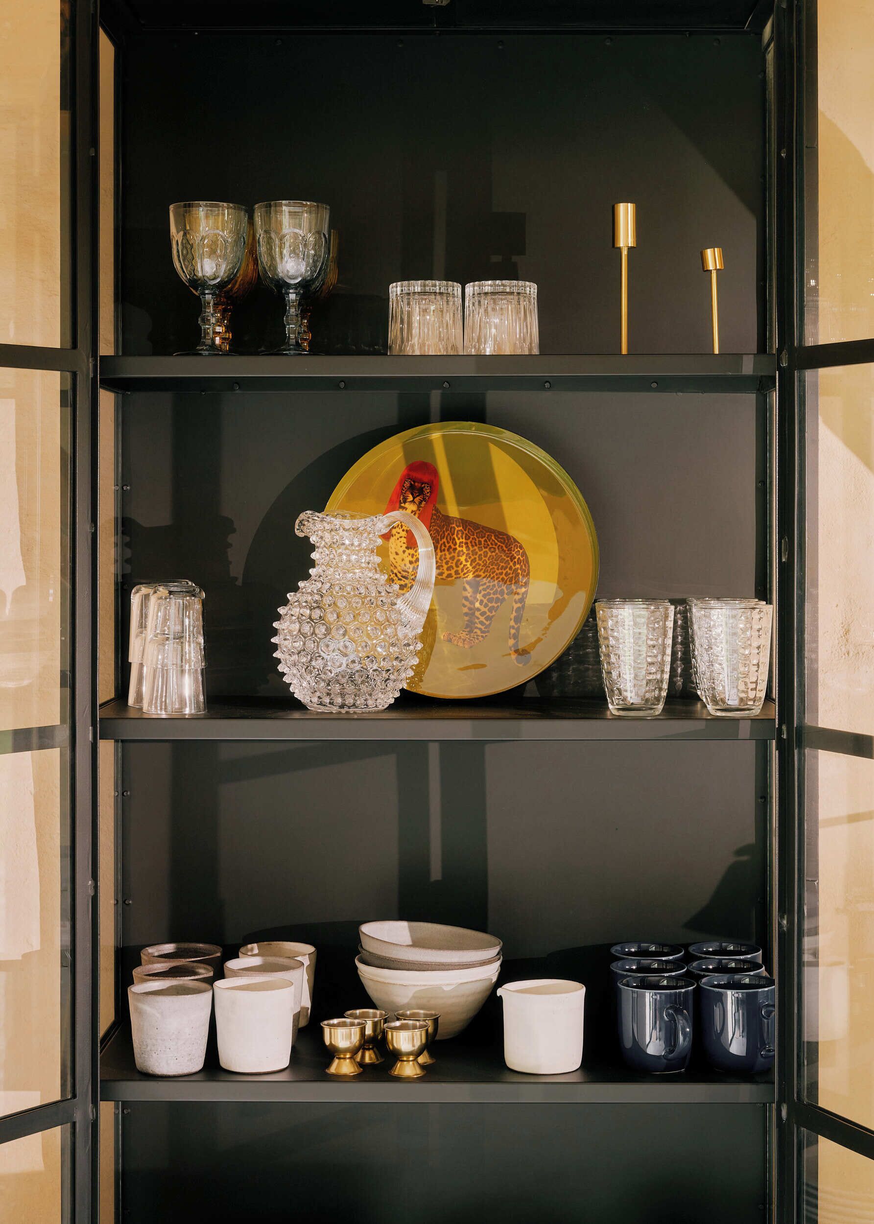 A display of glassware and ceramic items on shelves.