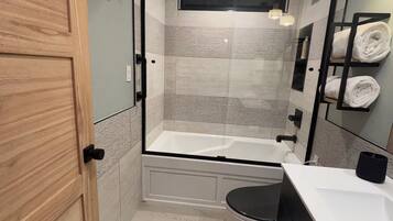 Un baño moderno con bañera, inodoro y lavabo.