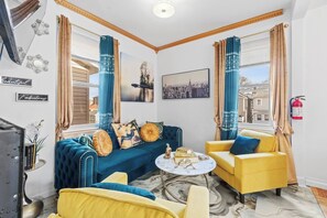 A modern living room with a blue sofa, yellow armchairs, and a marble coffee table. - VIP LUX-2 Bedroom Apart-15 min NYC-Shared Parking (Fairview)