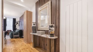 Un salon moderne avec un plancher en bois, un canapé, une table basse et un grand miroir au mur.