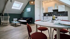 A modern loft apartment with a dining area, kitchen, and a cozy living space with a hammock. - En déplacement 10, les combles wifi gratuit (Tourcoing)