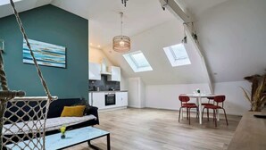 A spacious loft apartment with a kitchen, dining area, and living room. - En déplacement 10, les combles wifi gratuit (Tourcoing)