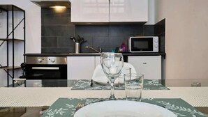 Une cuisine moderne équipée d’un four à micro-ondes, d’un four traditionnel et de placards.