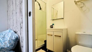 Un bagno con doccia, WC e lavandino.