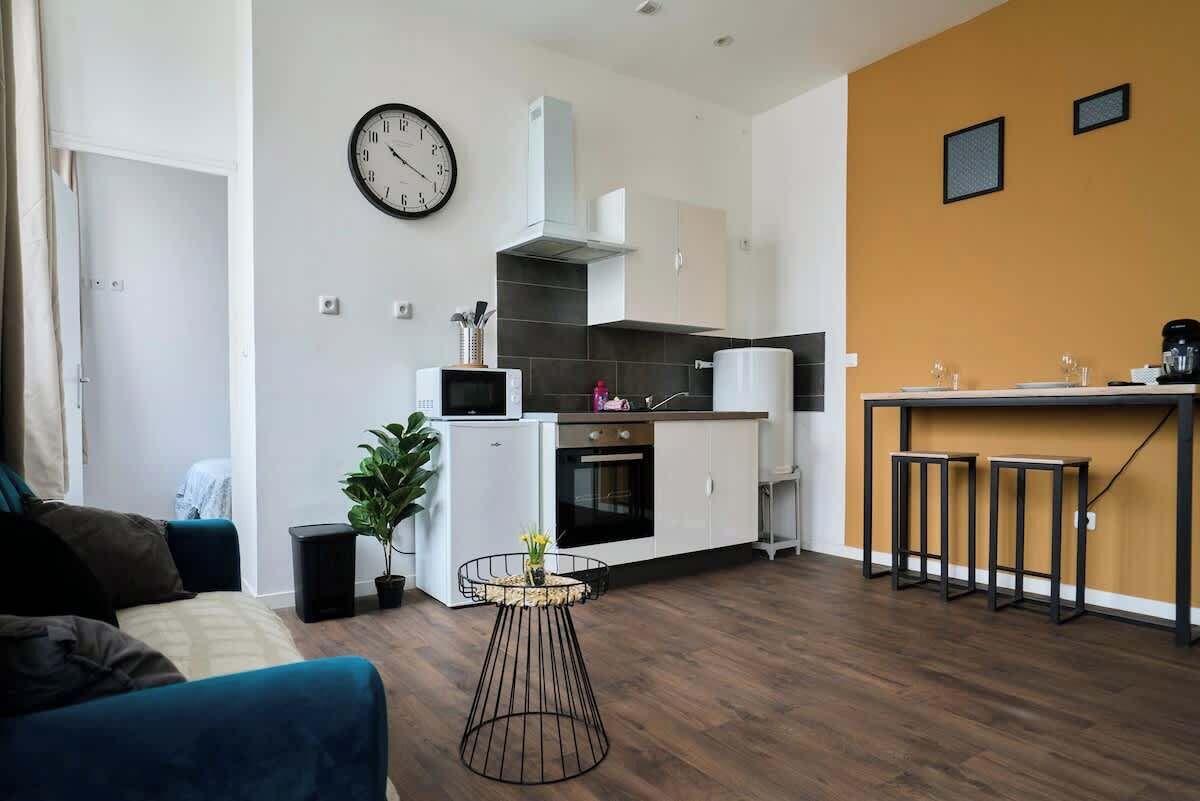 A modern apartment with a living area, kitchenette, and a dining area.