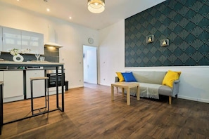Eine moderne Küche mit Essbereich, einer Couch mit Kissen und einer Wand mit Muster.