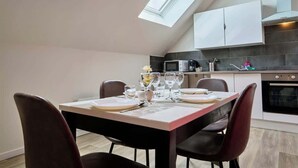A modern kitchen with a dining area, skylights, and a built-in oven. - En déplacement 9, Dernier étage, wifi gratuit (Tourcoing)