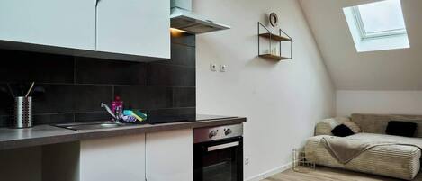 Een koelkast, een magnetron, kookgerei, borden en bestek