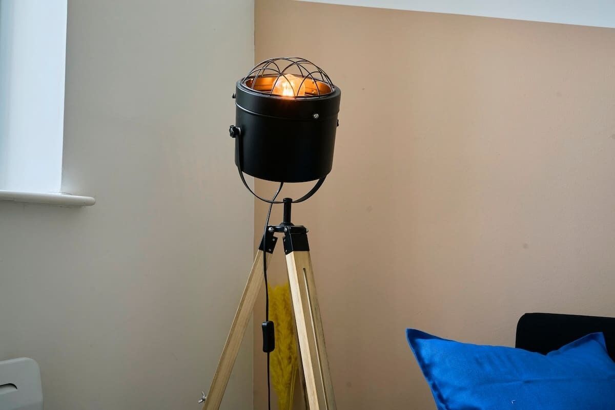 Een vloerlamp met een bolvormige lampenkap op een statief.