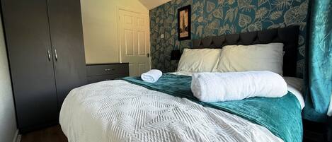 Un dormitorio con cama, armario, puerta y pared con diseño.