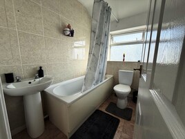 Un baño con bañera, lavabo e inodoro.