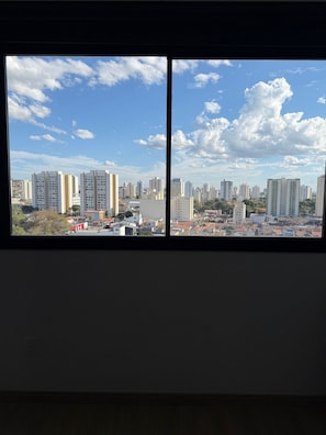A view through a window of a cityscape with high-rise buildings, a clear sky, and a McDonald's sign.