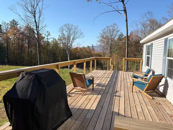 A wooden deck with outdoor seating and a grill. - Fabulous 4-bedroom house in Ludlow perfect for your ski getaway (Ludlow)