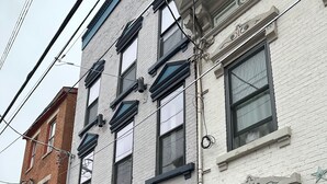 A two-story building with a white facade and black window frames. - Cozy 1-bedroom apartment in brilliant Cincinnati with AC (Cincinnati)