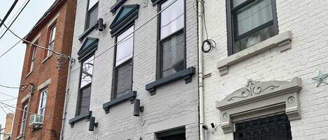 Un bâtiment à deux étages, doté d’une façade blanche et de cadres de fenêtres noirs.