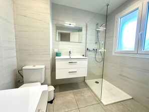 A modern bathroom with a glass-enclosed shower, a white sink, and a toilet. - Cozy apartment with terrace in Cannes (Cannes)