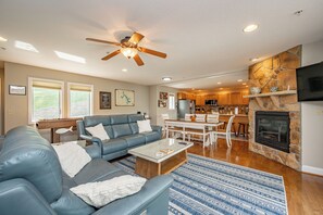 Ein modernes Wohnzimmer mit einem blauen Sofa, einem Couchtisch und einem Kamin.