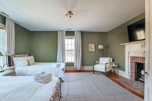 A hotel room with two beds, a fireplace, a television, and a window with curtains. - Barrel Sauna, Hot Tub & Views (Roseland)