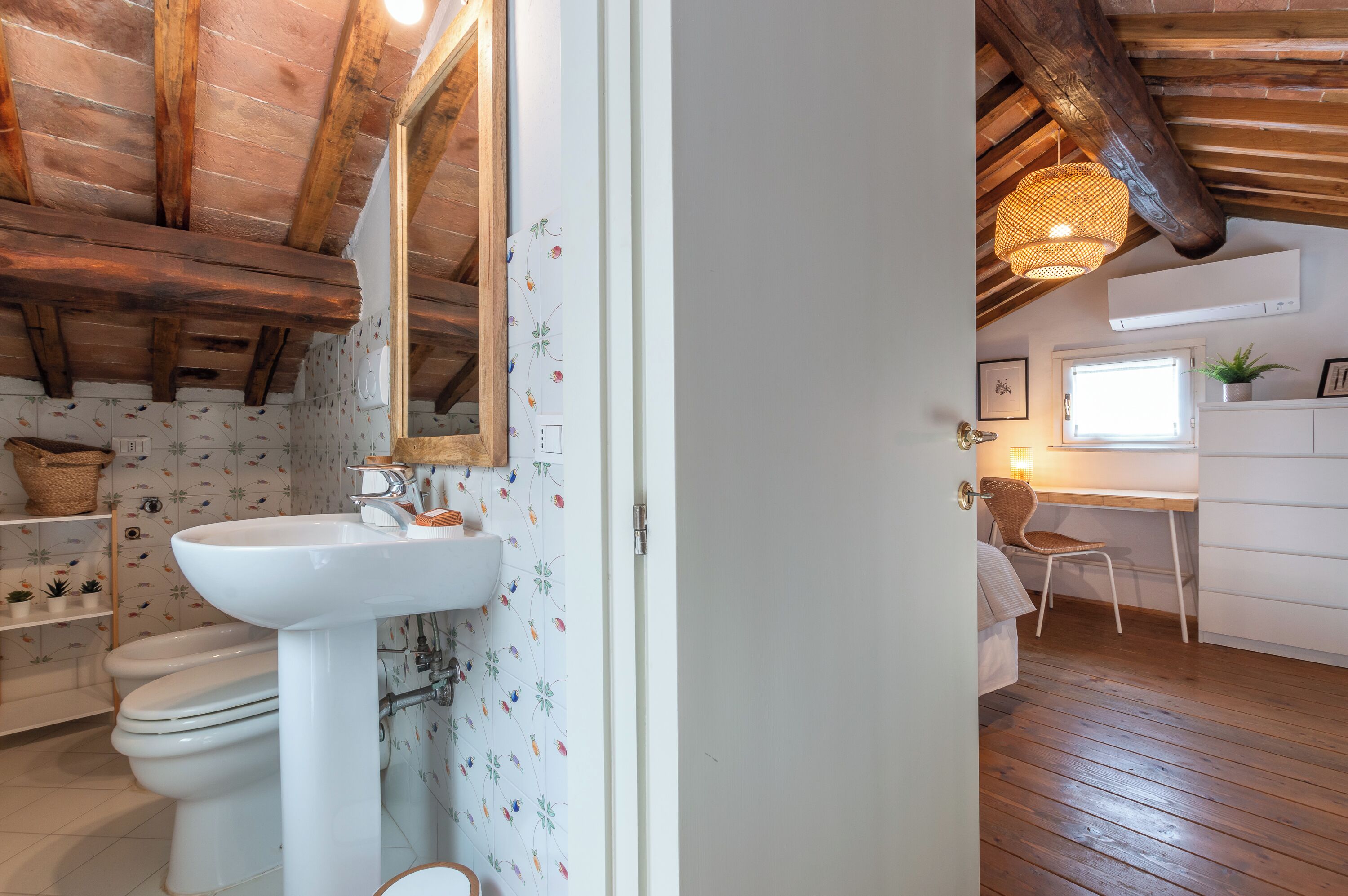 A rustic bathroom with a wooden ceiling, a white sink, and a mirror.