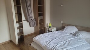 Una camera da letto con un letto, un comodino, una lampada e un armadio.