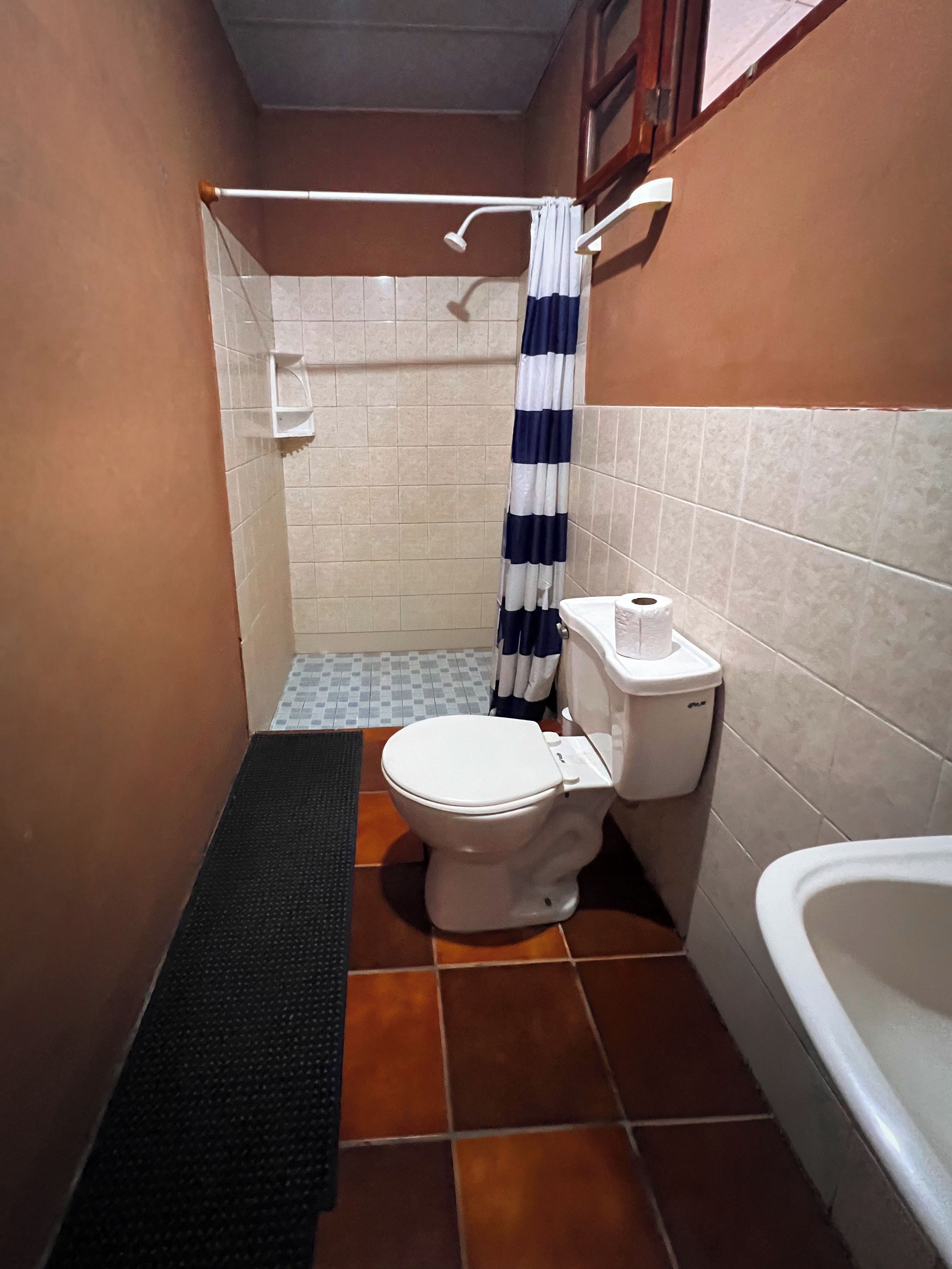 Ein kleines Badezimmer mit Toilette, Duschbereich und Badewanne.