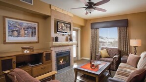A cozy living room with a fireplace, comfortable seating, and a scenic view. - Spacious 2-bedroom condo in serene Steamboat Springs (Steamboat Springs)