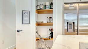 A kitchen with a stainless steel refrigerator, a white door with a 'to do list' sign, and wooden shelves holding kitchenware and a kettle. - 3BR Boundary Breeze Heated Pool Beach Golf Nearby (Rotonda West)