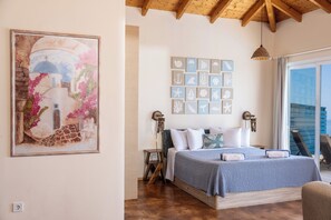 A bedroom with a bed, a wall-mounted artwork, a collection of framed nautical-themed artwork, and a view of the outdoors through a glass door. - Villa Sol. Welcome to your dream getaway. Breathtaking views in quiet location. (Magganos)