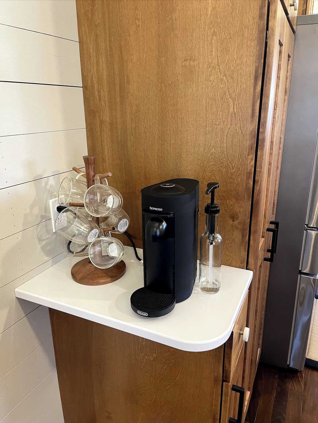 A kitchen counter with a coffee machine, a glass carafe, and a bottle of water.