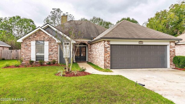 A single-story brick house with a garage, a front door, and a small front yard with a tree and shrubs. - Newly updated• 3BR/2BA • 7 Beds • Pets Welcome (Youngsville)