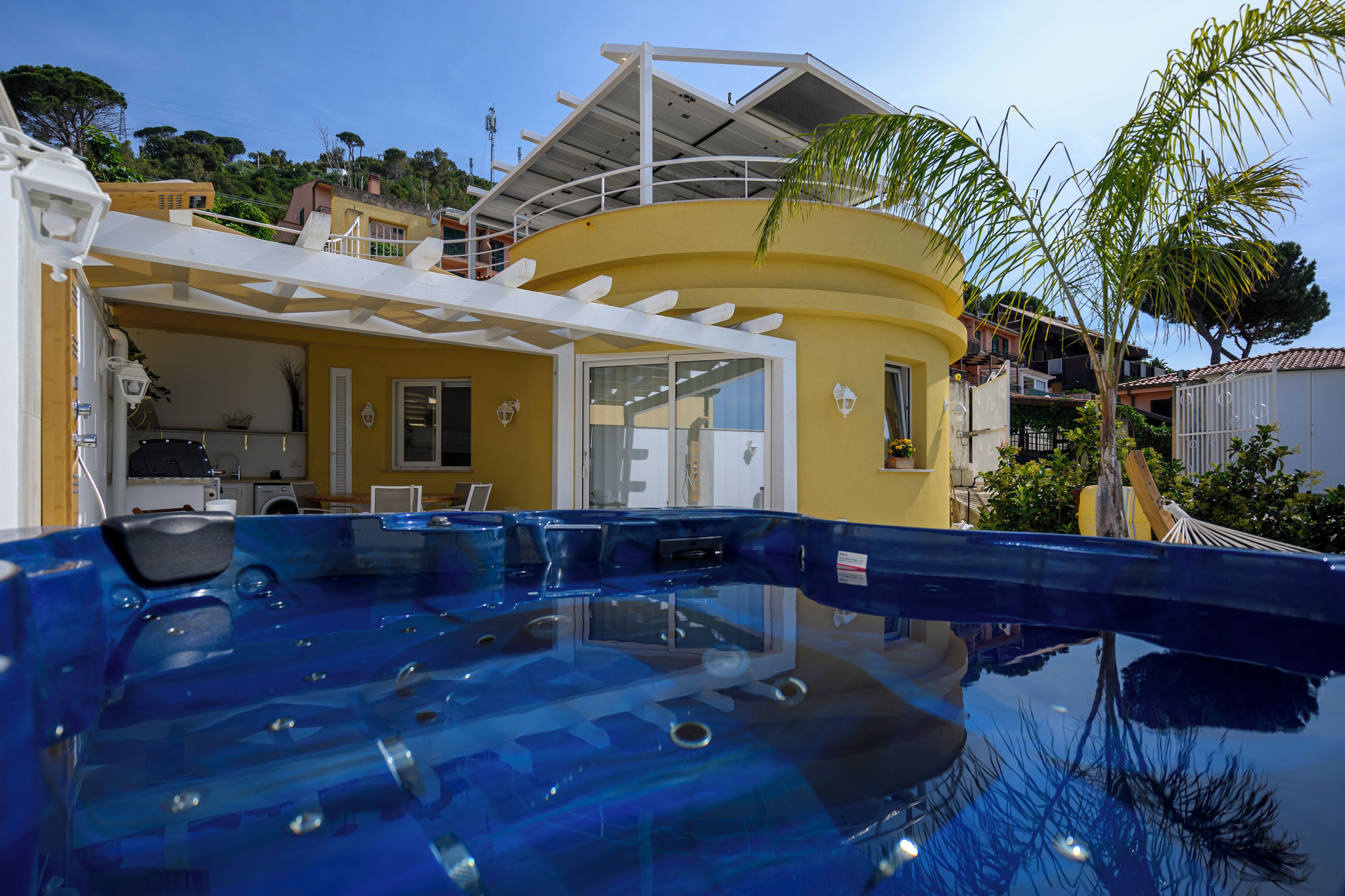 Zona de piscina con un edificio amarillo al fondo.