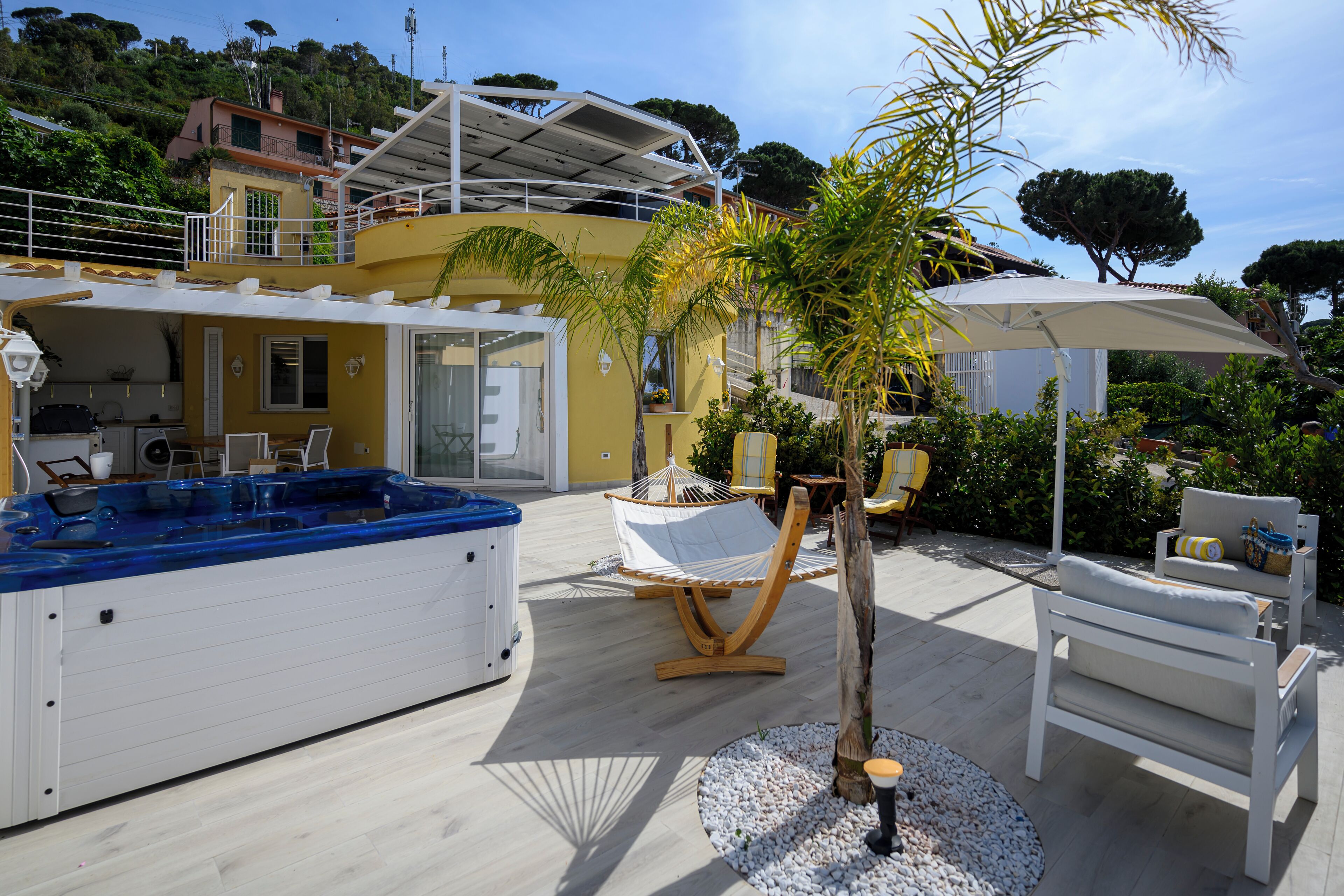 Ein Poolbereich mit Whirlpool, Liegestühlen und einer Palme.
