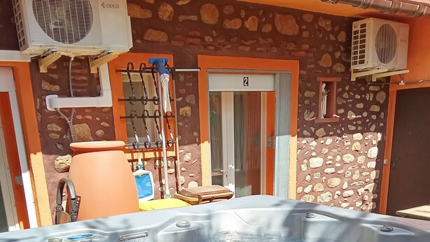 Un jacuzzi con una pared de piedra y dos unidades de aire acondicionado montadas en la pared.