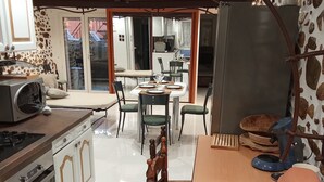 Una cocina con comedor, que incluye estufa, horno y una mesa de comedor con sillas.