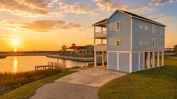 A two-story building with a balcony, located near a body of water with a dock.