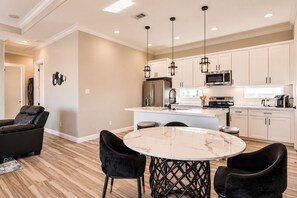 A modern kitchen with white cabinets, a central island, and pendant lighting. - Blissful Blue Oasis- Waterfront in Treasure Island (Freeport)