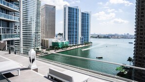 A modern high-rise building with a view of a river and other buildings in the background. - Luxe Brickell • 35th Floor • Skyline View • Free Spa & 5 Star Hotel Amenities (Miami)
