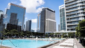 A modern hotel with a pool area, surrounded by high-rise buildings and a clear sky. - Luxe Brickell • 35th Floor • Skyline View • Free Spa & 5 Star Hotel Amenities (Miami)