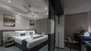 A modern hotel room with a large bed, a desk, and a chair. - Kzar Park (Kolkata)