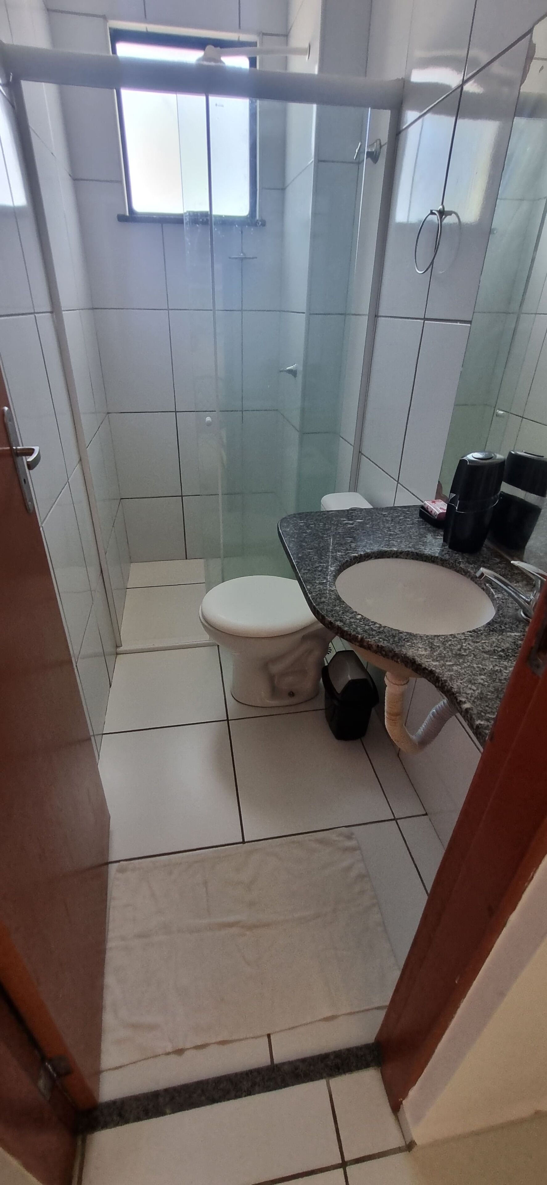A bathroom with a toilet, sink, and shower area.