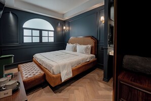 A bedroom with a large bed, a bench, a window, and a nightstand. - The Midnight Bloom Suite  (Mexico City)