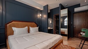 Un dormitorio moderno con una cama grande, cabecera de madera, mesita de noche y espejo.