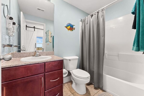 Een badkamer met een wastafel, toilet en bad.