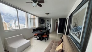 Een moderne woonkamer met een bank, eettafel en keukenhoek.