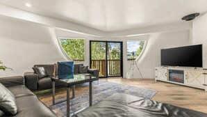 A modern living room with a leather sofa, a glass coffee table, a flat-screen TV, and a fireplace. - The Iconic Vail Dome, 7 Bedrooms in Vail (Vail)