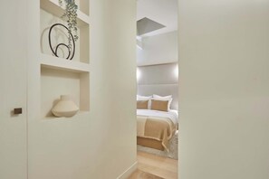 Ein Schlafzimmer mit einem Bett, einem Nachttisch und einer Wandregal mit Dekoration.
