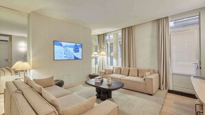 Una sala de estar moderna con un conjunto de sofá, una mesa de centro y un televisor de pantalla plana montado en la pared.