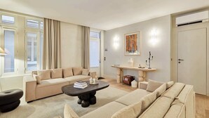 Una sala moderna con un sofá color beige, una mesa de centro oscura y una chimenea.