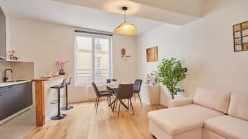 A modern apartment with a dining area, kitchen, and living room.